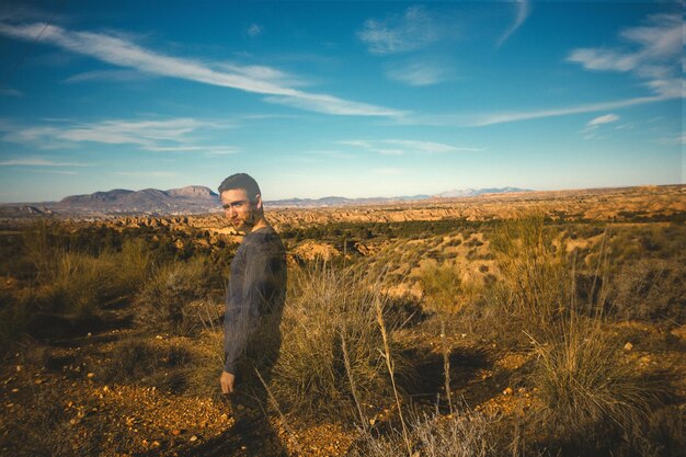 Double exposure of man with landscape against sky