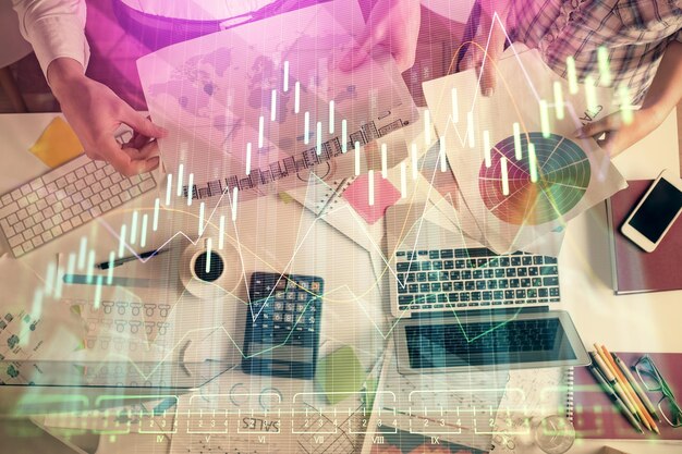 Double exposure of man and woman working together and financial chart hologram drawing market analysis concept Computer background Top View