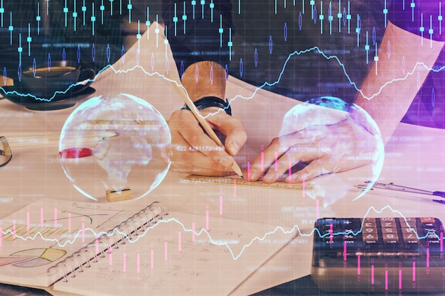 Double exposure of man writing on paper with forex graph