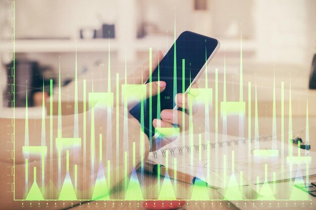 Double exposure of mans hands holding and using a digital device and forex graph drawing Financial market concept