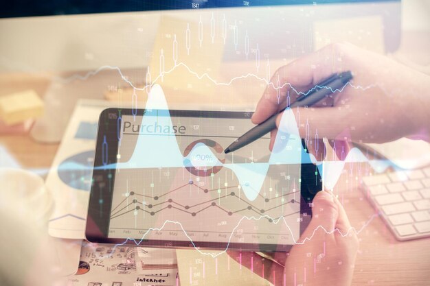 Foto doppia esposizione delle mani dell'uomo che tiene e usa un telefono e disegna grafici finanziari concepto di analisi di mercato