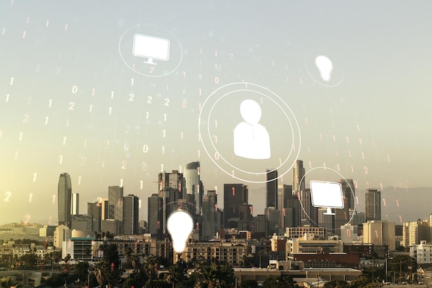 Double exposure of social network icons hologram on Los Angeles office buildings background Networking concept