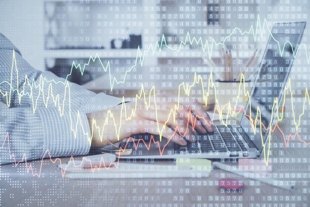 Двойная экспозиция графика фондового рынка с человеком, работающим на ноутбуке на заднем плане Концепция финансового анализа