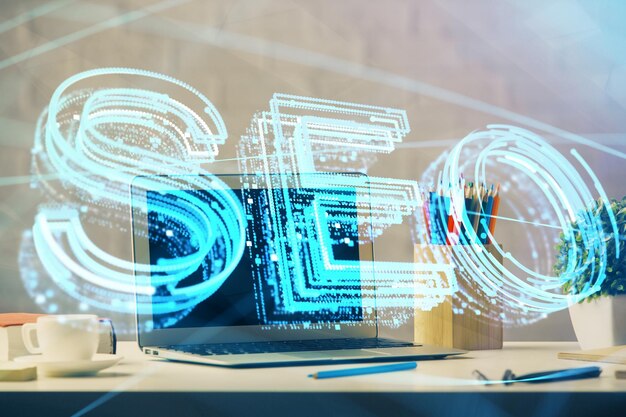 Double exposure of table with computer and seo drawing hologram Search optimization concept