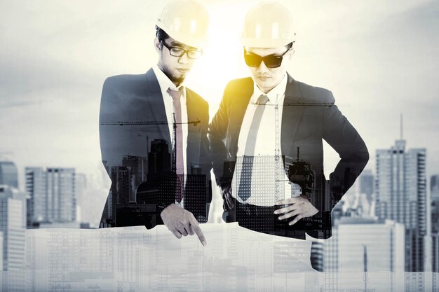 Double exposure of two engineer with blueprint