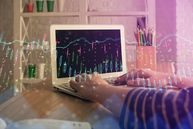 Foto doppia esposizione delle mani della donna che scrive sul computer e disegno olografico del grafico forex concetto di investimento in borsa