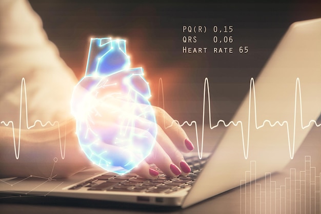 double exposure of woman hands typing on computer and heart hologram drawing education concept