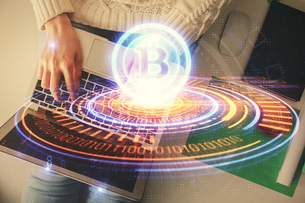 Double exposure of woman hands working on computer and blockchain theme hologram drawing Top View bitcoin cryptocurrency concept