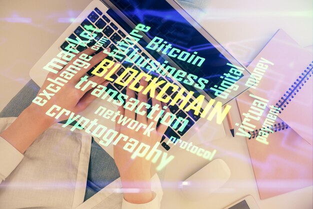 Double exposure of woman hands working on computer and blockchain theme hologram drawing Top View bitcoin cryptocurrency concept