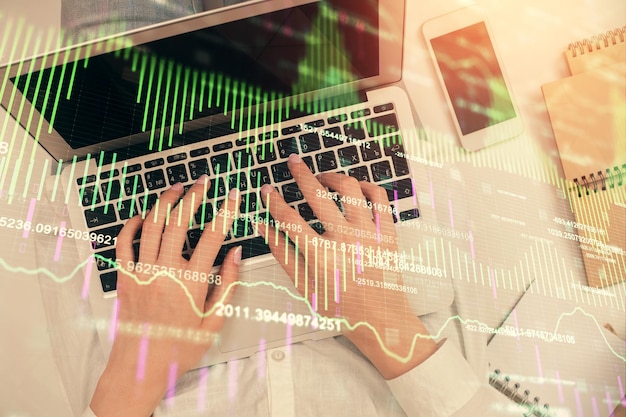 Double exposure of woman hands working on computer and forex chart hologram drawing Top View Financial analysis concept