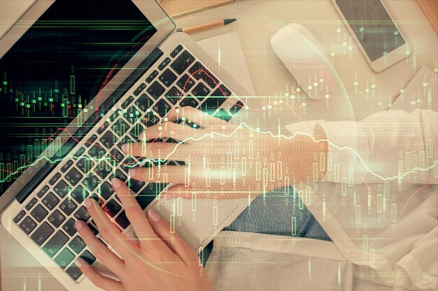 Double exposure of woman hands working on computer and forex chart hologram drawing Top View Financial analysis concept