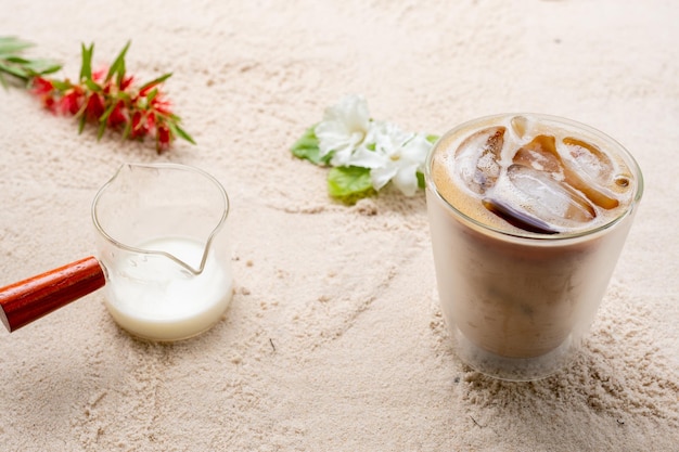 Doppio bicchiere di latte su sfondo di spiaggia di sabbia.