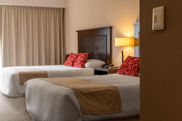 Double hotel bed with red cushions