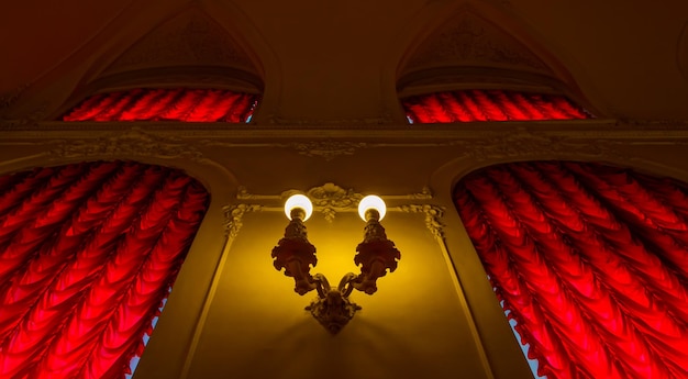 Foto una doppia lampada sul muro in un antico palazzo.