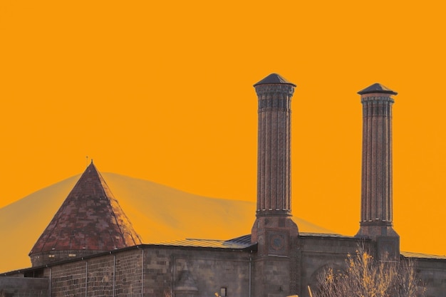 The double minaret madrasah . Yellow background. Erzurum, Turkey