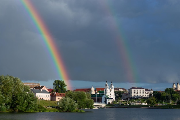 Photo double rainbow in the dark sky above the city