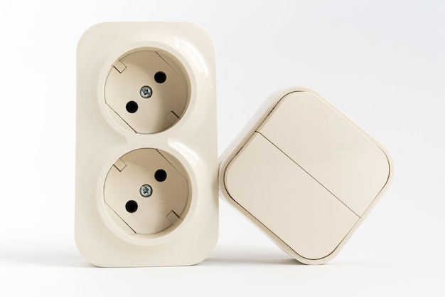 Double socket and twokey light switch on white background mechanical device for switching lighting circuit and two sockets connected by one monolithic case shop of electronic devices for the home