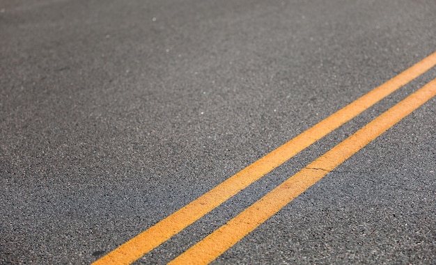 Фото Двойные желтые линии улиц символизируют регулирование дорожного движения, отсутствие объездных зон, границы дорог, безопасность.