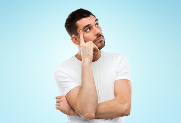 doubt, expression and people concept - man thinking over blue background