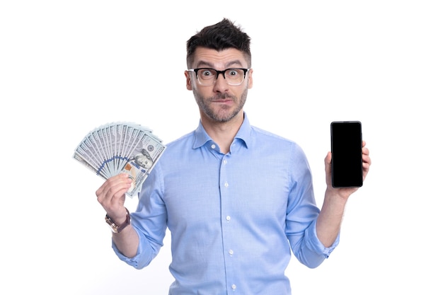 Doubtful guy showing cash money and smartphone Cash payment or smartphone payment