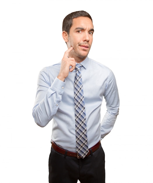 Doubtful young businessman doing a distrust gesture