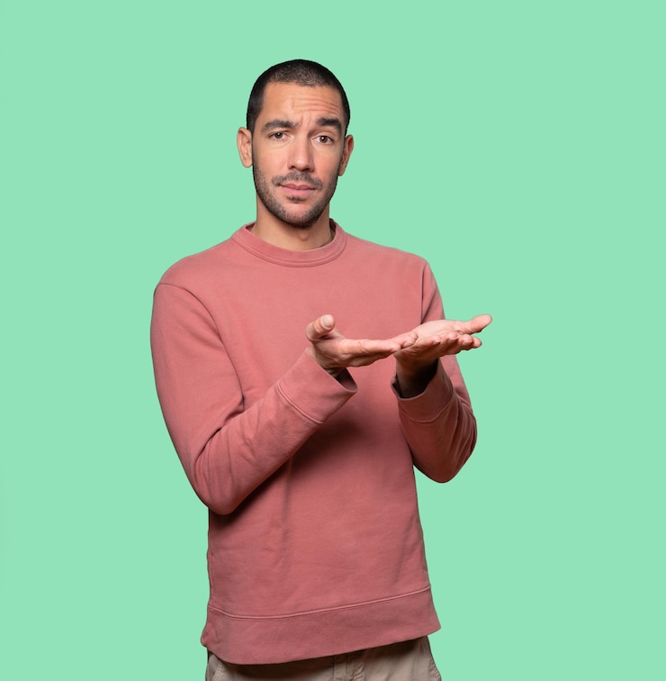 Photo doubtful young man holding something with his hand