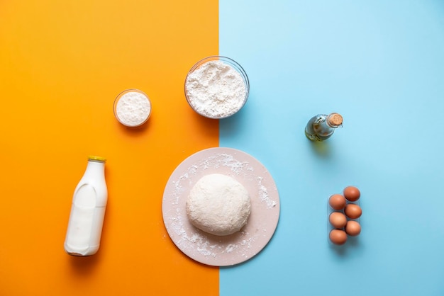 Dough and bake ingredients top view colorful background