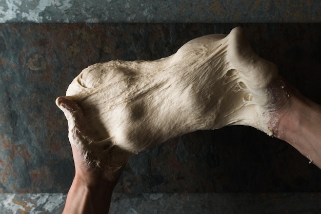 Dough for bread in the hands top view