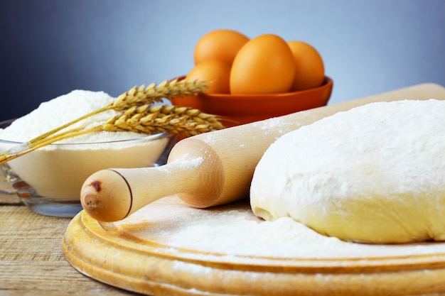 Dough and flour on a wooden board