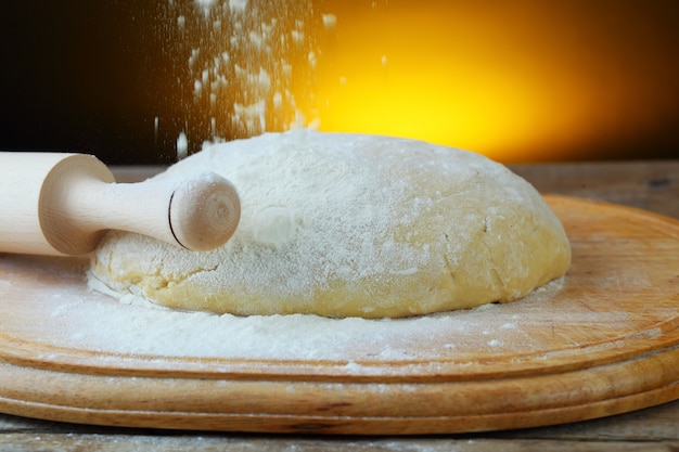 Dough and flour on a wooden board