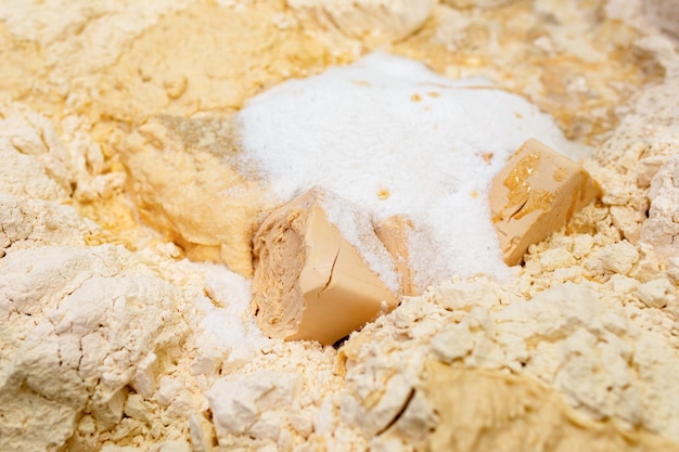 Dough ingredients: yeast, flour, sugar are ready for mixing in the bakery. Preparation of dough with professional kneader machine at the manufacturing.