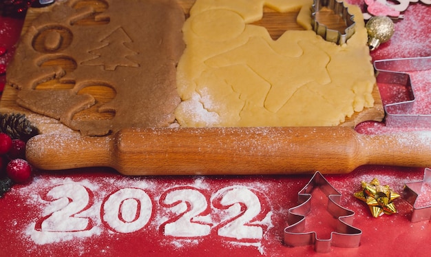 Photo dough for making homemade gingerbread cookies on a wooden board on a red backgroundchristmas