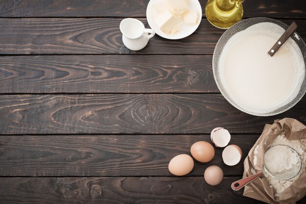 Dough and products for its preparation on  dark wooden background