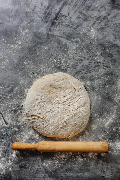 Dough and rolling pin lie on a table sprinkled with flour.