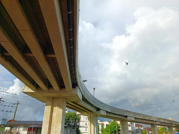 Doves sit and fly on electric wires against with concrete bridge into the sky