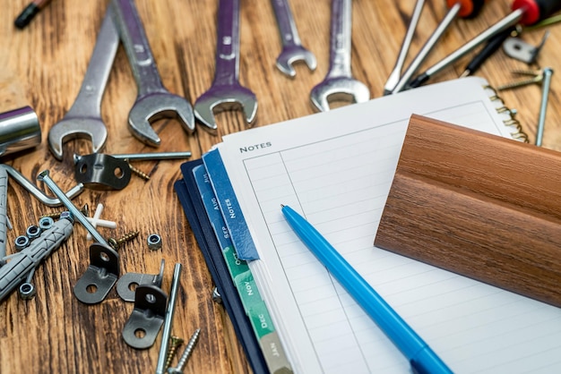 Dowel screws and keys are scattered on the table next to a folder and a pen