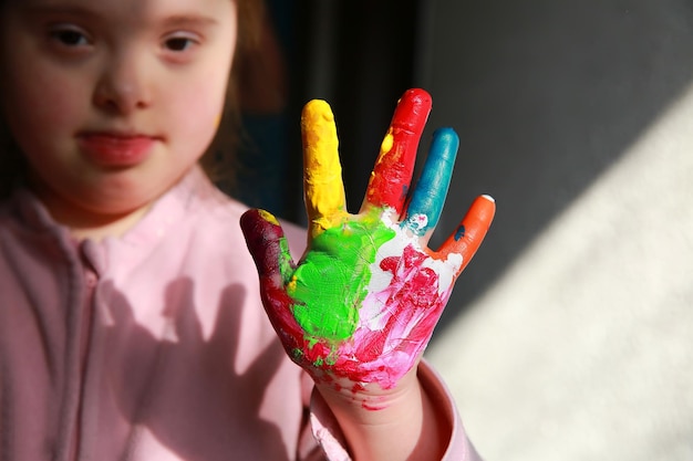 Down syndrome girl with painted hands