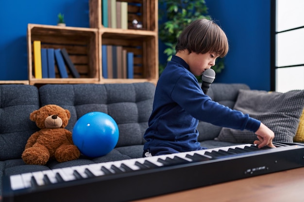 Down syndrome kid singing song sitting on sofa at home