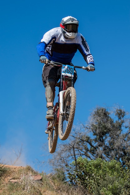 Downhill competition, Biker jumps fast in the countryside.