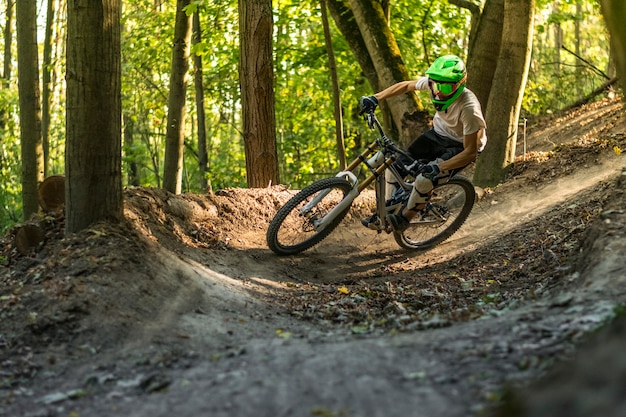 Downhill mountain biker in motion crossing trails.