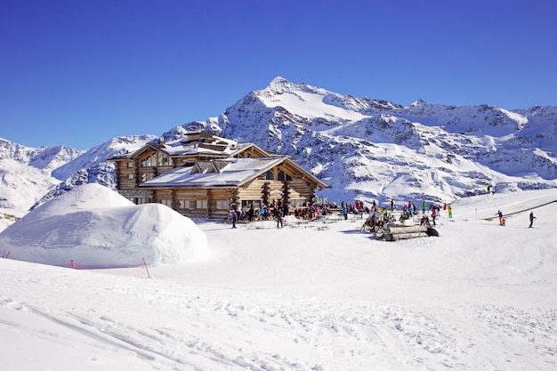 Discesa in discesa e apres ski baita con terrazza ristorante nelle alpi italiane, europa, italia. comprensorio sciistico santa caterina valfurva