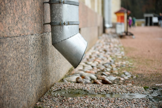 Downpipe close-up in de stad op een gebouw tijdens de regen