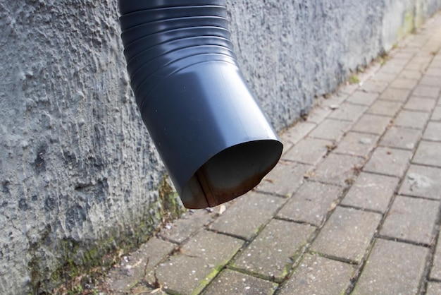 Foto downspout op de muur boven het trottoir