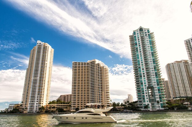 Downtown miami along biscayne bay with condos and office buildings yacht sailing in the bay at sunny day