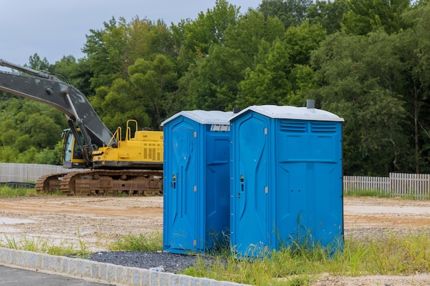 Draagbaar toilet op huis in aanbouw in bouwwerf voor arbeider