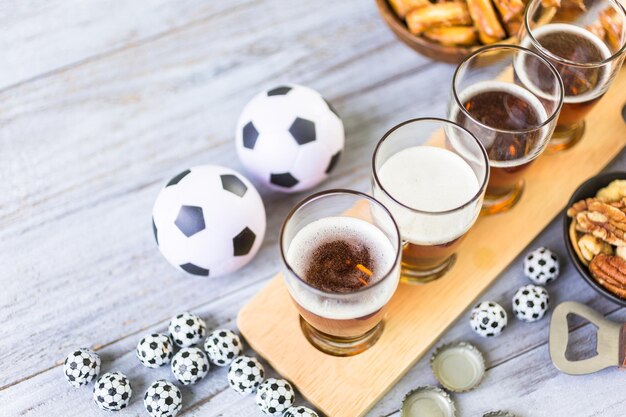 Draft beer and salty snacks on the table for soccer party.