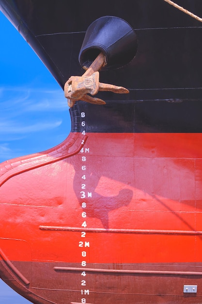 写真 改修作業後の石油タンカー船の赤と黒の金属の船体表面のドラフトマーク番号