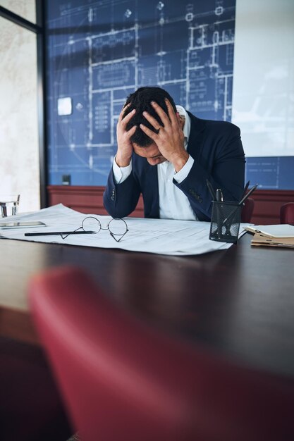 Photo draftsman having a severe headache in the workplace