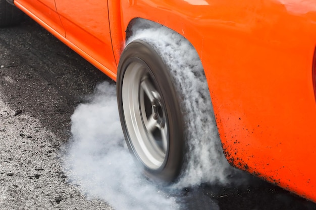 Foto l'auto da corsa di trascinamento brucia la gomma dai suoi pneumatici in preparazione per la gara