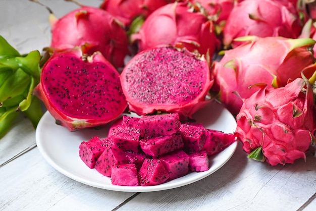 Fetta di frutta drago e metà tagliata su piatto bianco con sfondo pitahaya fresco rosa rosso porpora drago frutta tropicale nel concetto di frutta sana tailandia asiatica